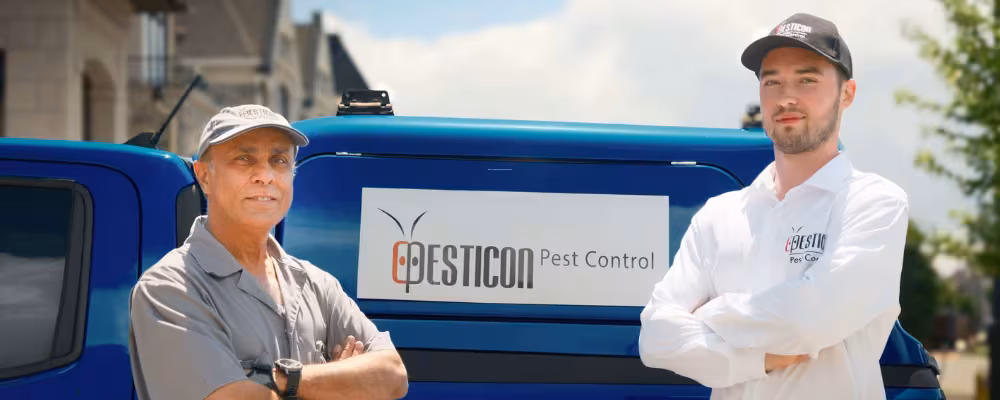 Pesticon pest control technicians standing in front of service vehicle